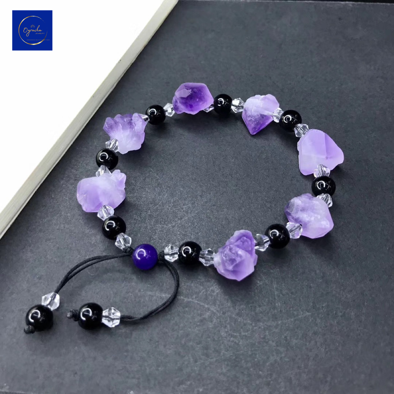 "Beautiful amethyst bracelet featuring raw purple stones and black beads, captured from a top-down angle, by Oyracha Jewelry. This handcrafted bracelet symbolizes spiritual protection and balance, ideal for those seeking zodiac-inspired gemstone accessories. Explore Oyracha's unique gemstone jewelry collection."