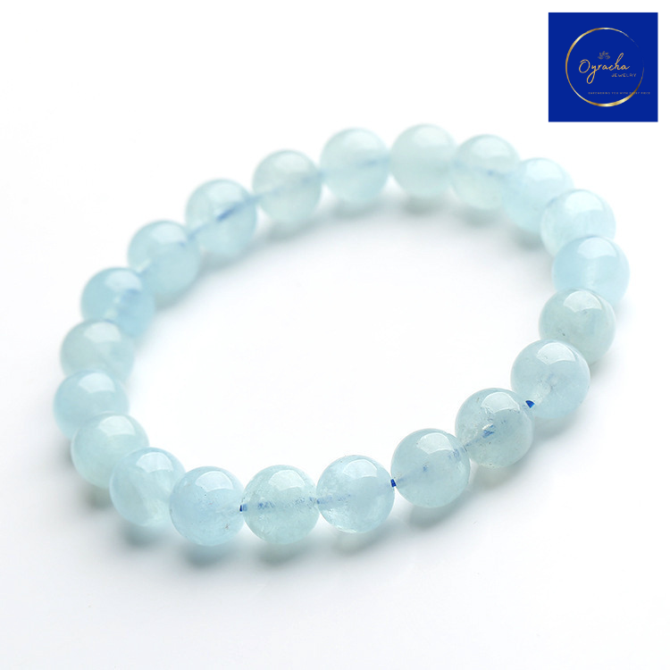 Top angle view of a delicate aquamarine bead bracelet, showcasing the soft blue tones and smooth round beads. This Oyracha Jewelry aquamarine bracelet exudes calmness and serenity, perfect for individuals seeking a connection to tranquility and inner peace.
