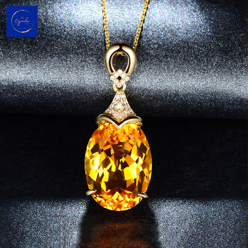 Front angle view of a luxurious citrine pendant necklace from Oyracha Jewelry, showcasing the brilliant-cut citrine gemstone encased in a gold setting with diamond accents. The necklace is illuminated against a dark background, highlighting the vibrant glow and intricate details of this elegant piece.