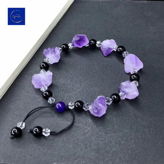 "Beautiful amethyst bracelet featuring raw purple stones and black beads, captured from a top-down angle, by Oyracha Jewelry. This handcrafted bracelet symbolizes spiritual protection and balance, ideal for those seeking zodiac-inspired gemstone accessories. Explore Oyracha's unique gemstone jewelry collection."