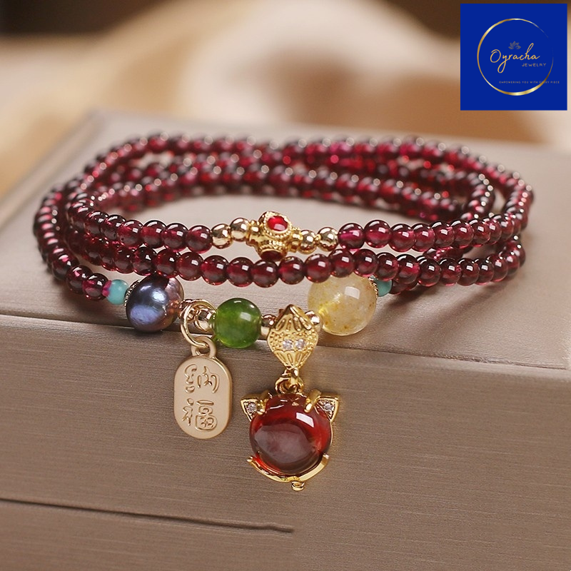 "Beautiful multi-strand garnet bracelet with colorful gemstone accents and gold charms, captured from a front angle view, by Oyracha Jewelry. This handcrafted piece symbolizes prosperity and protection, ideal for those seeking zodiac-inspired gemstone accessories. Explore Oyracha's gemstone and zodiac jewelry collection."