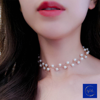 Front view of a delicate pearl choker necklace from Oyracha Jewelry, worn elegantly around the neck. The pearls are arranged in a branch-like design, adding a touch of sophistication and natural beauty. This minimalist yet luxurious accessory is perfect for special occasions or adding a refined accent to everyday looks