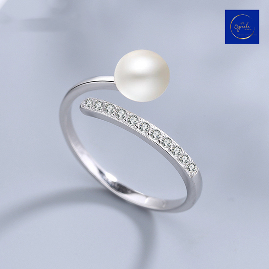 "Elegant open-ended pearl ring with cubic zirconia accents, captured from a front angle view, by Oyracha Jewelry. This minimalist yet sophisticated design symbolizes purity and elegance, perfect for pairing with any outfit. Explore Oyracha's pearl and gemstone jewelry collection."