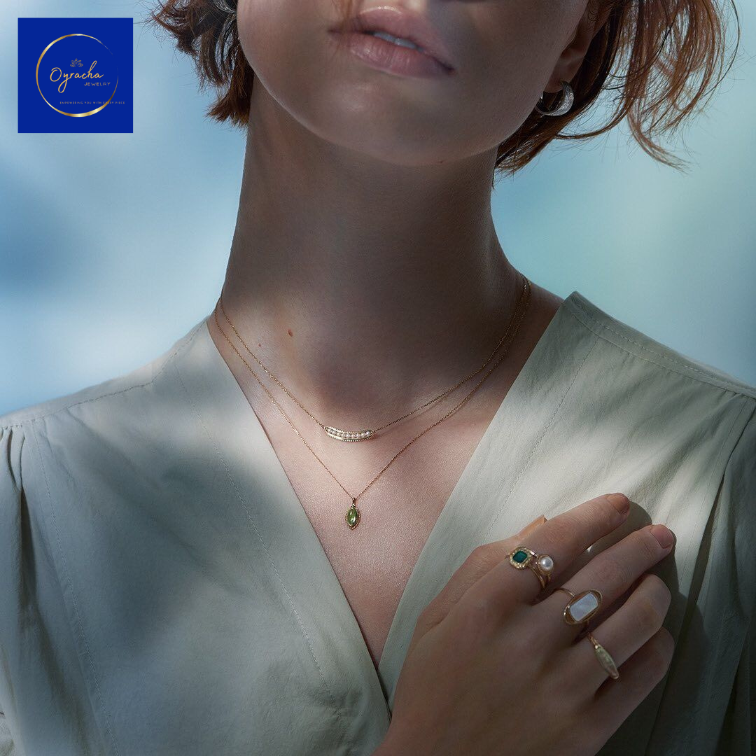 "Elegant model wearing Oyracha Jewelry's delicate layered necklaces and rings, featuring a stunning peridot pendant and pearl ring. Perfect for enhancing any outfit with subtle luxury and natural gemstone beauty. Shop Chinese zodiac-inspired jewelry collection at Oyracha."